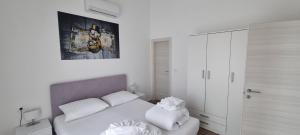 una camera bianca con letto e armadietto bianco di Penthouse Dream Vista a Čižići Altre 10 foto