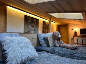 a teddy bear sitting on a bed with a blanket at Portes du Soleil T3 "comme un chalet" direct access Morzine Avoriaz in Montriond +17 photos