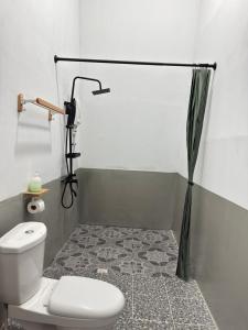 ein Badezimmer mit Toilette und Duschvorhang in der Unterkunft Bongga Village Resort in Semporna