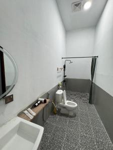 ein Badezimmer mit Toilette, Waschbecken und Spiegel in der Unterkunft Bongga Village Resort in Semporna