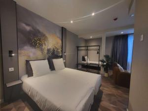 a bedroom with a large white bed with a painting on the wall at Nebula Hotel by Ine's in Assendelft +19 photos
