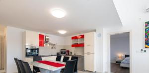 a kitchen and dining room with a table and chairs at Penthouse Dream Vista in Čižići