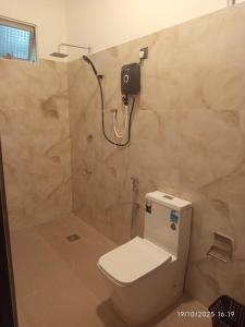 a bathroom with a toilet and a shower at Scenic Cottage Sigiriya in Sigiriya