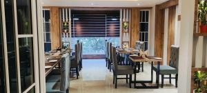 a dining room with wooden tables and chairs at hotel Green view in Baharampur