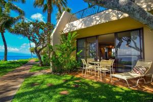 una casa con una mesa y sillas en el patio en Napili Point A8 · NP A8 OceanFront 1BD Condo w Ocean Views AC Po, en Kahana