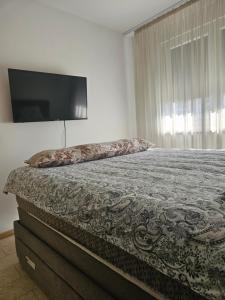 a bedroom with a bed and a flat screen tv at Miss Extra LuX in Mladenovac