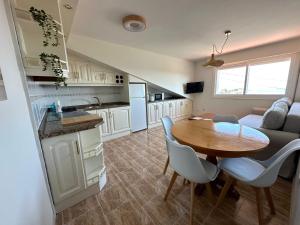 a kitchen and living room with a table and a couch at Apartamento Balea - San Vicente do Mar in Balea