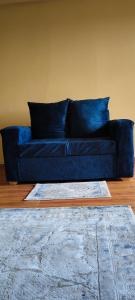 a blue couch sitting in a living room with a rug at Nyota Haven Stays in Libwezi +2 photos