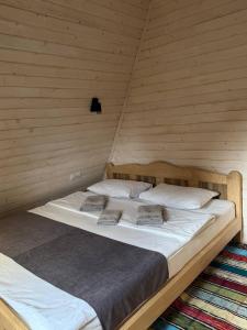 a large bed in a room with a wooden wall at Soul House in Pilipets +55 photos