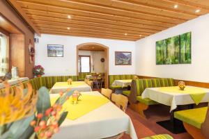 a restaurant with tables and booths with yellow and green furniture at Haus Gafrina in Schruns-Tschagguns