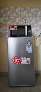 a microwave sitting on top of a refrigerator at Nyota Haven Stays in Libwezi
