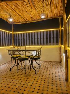 a table and chairs in a room with a ceiling at Quiet coastal house in the heart of Essaouira in Essaouira