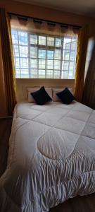 a bedroom with a large white bed with a window at Nyota Haven Stays in Libwezi