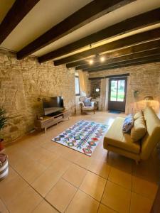 a living room with a couch and a tv at Self contained Guest House in Juillé in Juille
