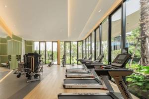 a gym with a row of treadmills and exercise machines at Cozy Palm Haven apartment in Kathu