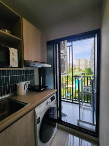 カトゥーにあるCozy Palm Haven apartmentのキッチン(洗濯機付)、バルコニーが備わります。