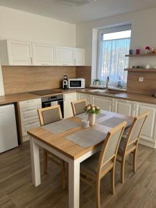 a kitchen with a wooden table and chairs in a kitchen at Apartmány Starý Blich in Bardejov