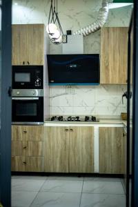een keuken met houten kasten en een kookplaat met oven bij WD exquisite luxury apartment in Lekki