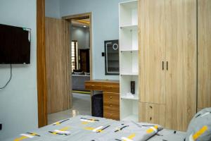 een kamer met een bed, een tv en een keuken bij WD exquisite luxury apartment in Lekki +4 foto's
