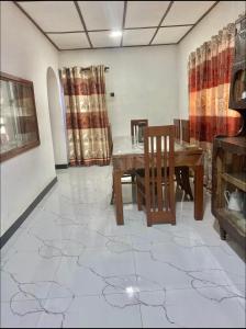 a dining room with a table and chairs on a tile floor at Heart Whispering in Kandy