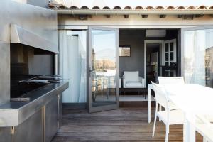 a kitchen with a counter and chairs and a table at La Résidence Arles Centre in Arles