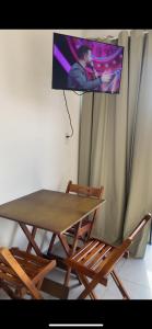 ein Tisch und zwei Stühle mit einem Fernseher darüber in der Unterkunft Chalé Por do Sol in Caparaó Velho