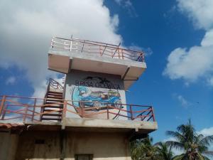 Una torre en la parte superior de un edificio con una pintura en ella. en Brisa Oceanica, en Itarema