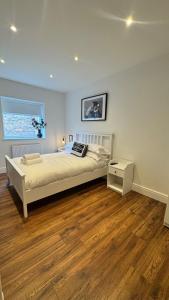 a bedroom with a large bed and a wooden floor at Entire apartment in Waterloo, Crosby, Liverpool in Crosby