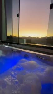 einen Whirlpool mit Blick auf den Sonnenuntergang in der Unterkunft Chalé Por do Sol in Caparaó Velho + 4 Fotos