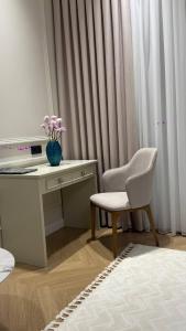 a white desk with a chair and a vase of flowers at Symphony Boutique in Tashkent