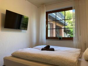 a teddy bear sitting on a bed in a room with a window at Ferienwohnung Dorfliebe Minden by Engelmann in Minden