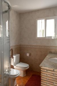 Un baño con inodoro, lavabo y ventana. en Your Paradise with Pool - 2 min from Beach, en Moncófar