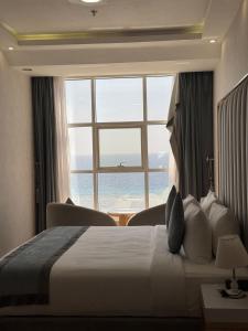 a hotel room with a bed and a large window at Rose Land Hotel in Umm Lajj +48 photos