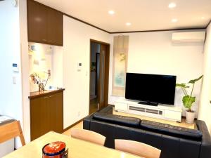 a living room with a couch with a flat screen tv at TSURUNOYA The only private lodging in Tokyo Japanese TATAMI style 8 minutes walk from station FREE Parking NEW OPEN ASAKUSA AKIHABARA SKYTREE nearby in Tokyo +47 photos