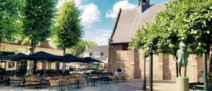 Un restaurante con mesas y sillas y una estatua de una mujer. en Bed and Breakfast 't Teutenhuys Eersel, en Eersel