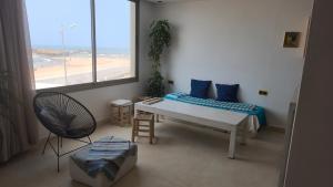 una habitación con una cama y una mesa y una ventana en Live & Work in Essaouira, en Essaouira