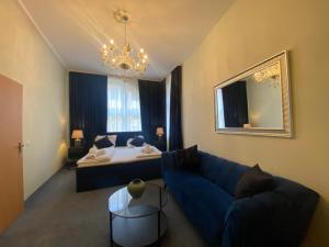 a living room with a blue couch and a bed at Luitpold Hotel in Nuremberg