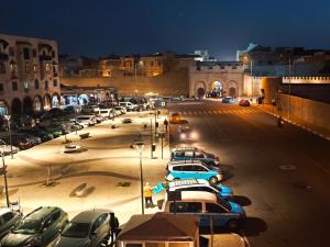 un estacionamiento con autos estacionados en una ciudad por la noche en Live & Work in Essaouira, en Essaouira