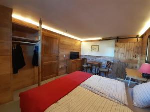 a bedroom with a large bed with a red blanket at Kuhstall Suite mit Bad in Nenzlingen