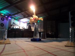 安東尼奧港的住宿－La Familia Guest House and Natural Farm，一张桌子上放着蜡烛的花瓶