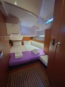 een kleine kamer met een paars bed in een boot bij Sailing boat house in Athene