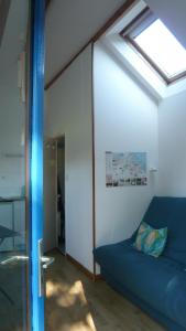 a room with a blue couch and a window at Châtaigne in Plouézec