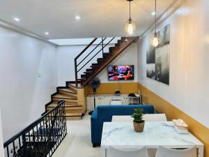 a living room with a blue couch and stairs at Layover at 1146 in Manila