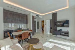 a living room with a table and a kitchen at Villa Di Montagna wellness & spa in Zlatibor