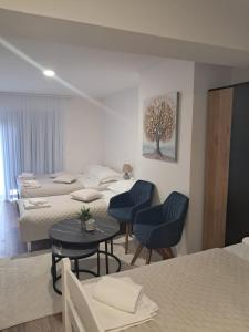 a room with three beds and a table and chairs at Galija in Tomislavgrad