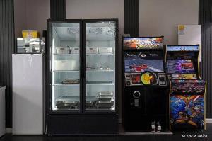 a black refrigerator next to a video game at אחוזת אורפז - וילה מדהימה עם בריכה פרטית מחוממת וג'קוזי בזרעית in Zar‘it