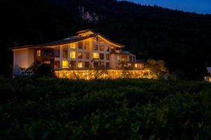 a large building with lights in a field at night at 重庆金佛山古核隐庐Resort Hotel in Nanchuan