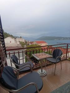 a balcony with chairs and a table and a view of the water at Apartman Herceg Novi in Herceg-Novi