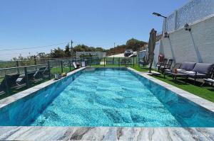 a swimming pool with blue water on top of a building at אחוזת אורפז - וילה מדהימה עם בריכה פרטית מחוממת וג'קוזי בזרעית in Zar‘it