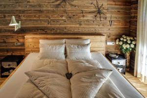 a large bed in a room with wooden walls at Sunny Hideaway in Hart im Zillertal
